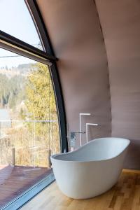 a bath tub in a bathroom with a large window at Глемленд in Yaremche +117 photos