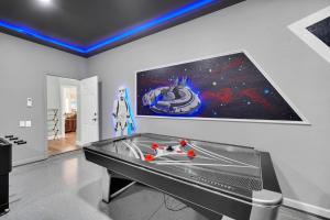 a ping pong table in a room with a painting on the wall at Getaway Cove Villa in Orlando