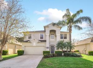 a house with a palm tree and a driveway at Getaway Cove Villa in Orlando