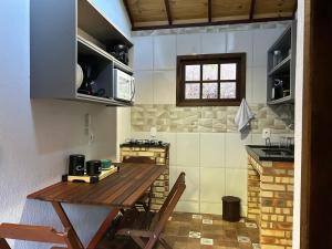 a kitchen with a wooden table and chairs in a room at Chalé dos ipês in Nova Friburgo +23 photos