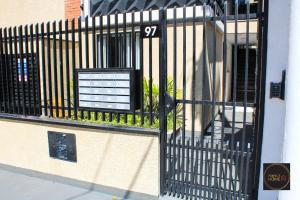 a black gate with a sign on the side of a building at Perfect Home in Guarulhos