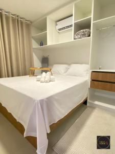 a bedroom with a bed with white sheets and towels at Perfect Home in Guarulhos