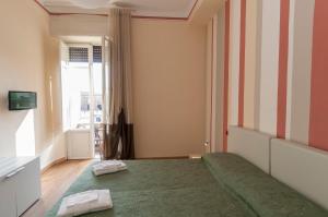 1 dormitorio con 1 cama con 2 toallas en Nonna Adriana, en Lucca