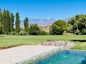a swimming pool with a field and mountains in the background at FINCA TIERRA CALMA Casa 1 in Hilario