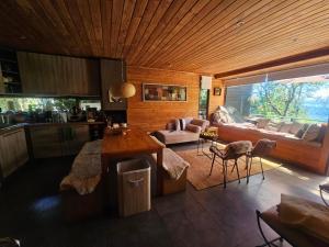 Una cocina y una sala de estar con un sofá y una mesa. en Casa Orilla Lago, en Villarrica