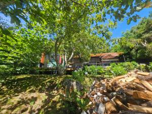 una casa con un árbol y un montón de rocas en Casa Orilla Lago, en Villarrica