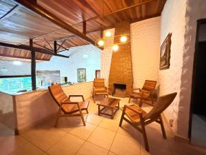 a living room with chairs and a fireplace at EcoHotel Vale do Sol in Embu