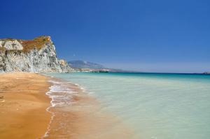 a beach with the ocean and a cliff at Kefalonia Beach Hotel & Bungalows in Lixouri