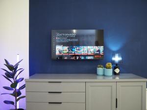a room with a tv on a blue wall at Tamerici Salmastre-Montesilvano in Montesilvano
