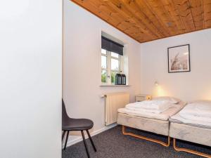 a bedroom with a bed and a chair at Luxury Lodge with Limfjord View - By Traum Ferienwohnungen in Spottrup +59 photos