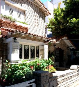 a white brick house with some plants in front of it at Hotel Medina y Mar BnB in Mar del Plata