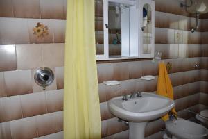 a bathroom with a sink and a yellow shower curtain at Lacona in Lacona +13 photos