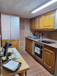 a kitchen with wooden cabinets and a table and a sink at San Roque 52 in Combarro