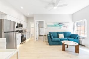 a living room with a blue couch and a kitchen at Siesta Key Village, Heated Pool, Beach Access 4 min Walk, 1bdr in Siesta Key