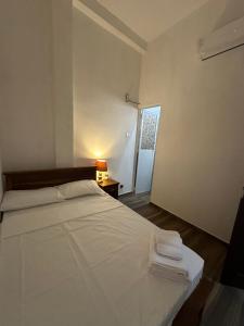 a bedroom with a white bed with towels on it at Nomad House in Kandana