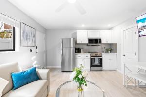 a white living room with a couch and a kitchen at Beach Rd, 300ft to Beach Access & 500ft to Siesta Key Village, 1bdr in Siesta Key