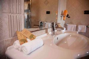 a bathroom with a sink with towels and a mirror at La Dimora del Cavaliere - Stupenda Dimora a 5 Min Dal Lago di Martignano in Anguillara Sabazia +47 photos
