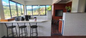 a kitchen with a counter with four bar stools at Casa Serra dos Cavalos in Teresópolis