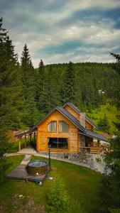 a log cabin with a hot tub in the yard at Cabana BellaMonte in Vartop +26 photos
