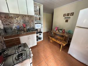 a kitchen with a stove and a table in it at Sítio recanto toca da onça in Nova Friburgo