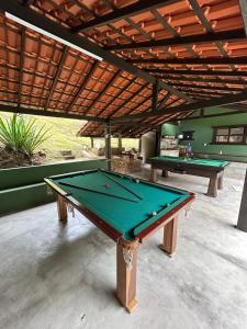 a pool table sitting under awning in a patio at Sítio recanto toca da onça in Nova Friburgo