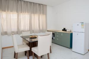 a kitchen with a table and chairs and a refrigerator at Your Escape Home in Praia in Praia +10 photos