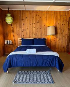 una camera con letto blu e pareti in legno di Joshua Tree Ranch House Motel - Downtown - Room #8 a Joshua Tree