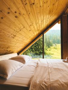 a bed in a room with a large window at Cabana BellaMonte in Vartop