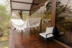 a hammock on a screened in porch with a chair at Cabaña Jaguar in Flores