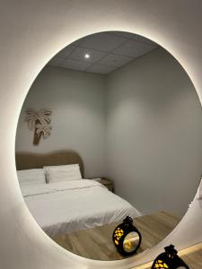a bedroom with a bed and a round mirror at سكينة المدينة 101 in Al Madinah