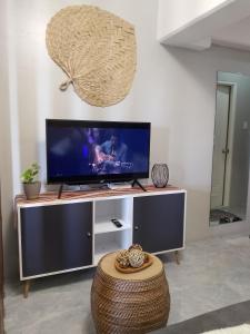 un soggiorno con TV a schermo piatto su un centro di intrattenimento di C&W Royal Oceancrest Mactan a Sudtungan