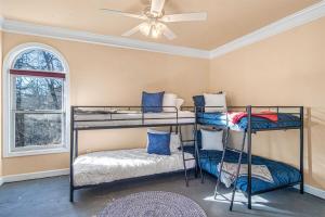 two bunk beds in a room with a ceiling fan at Majestic River Castle, A Fairytale Escape on the Coosawatee River in Ellijay +50 photos