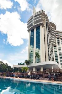 a large building with a swimming pool in front of it at Tropical Executive Flat Suites 518 Veiw in Manaus