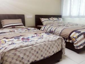 dwa łóżka siedzące obok siebie w sypialni w obiekcie 30 Guest House w Malakce