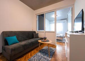 波德戈里察Podgorica City Center的客厅里有一张沙发和一张桌子。