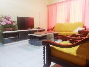 a living room with a couch and a television at 30 Guest House in Malacca