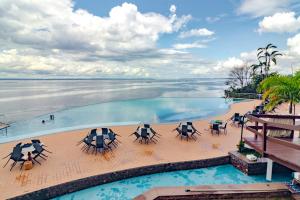 una piscina infinita con mesas y sillas y vistas al océano en Tropical Executive Suite Flat 1001 Veiw, en Manaus