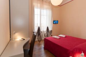 a bedroom with a red bed and a window at Nonna Adriana in Lucca