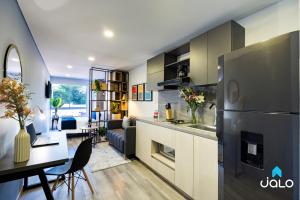 cocina y sala de estar con mesa y nevera en Cabrera 85 Apartments By Jalo, en Bogotá