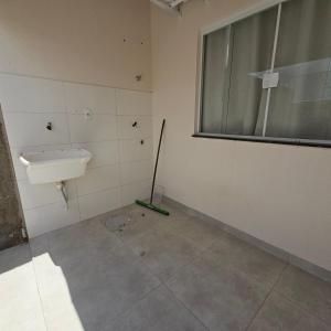 a bathroom with a sink and a mop at Casa Nova 02 in Primavera do Leste +9 photos