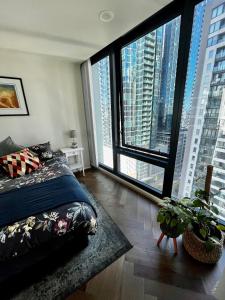 a bedroom with a bed and large windows at Luxury 2BR Apartment, Pool, Gym & Free Parking in Melbourne