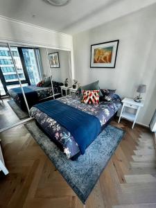 a bedroom with a bed with a blue comforter at Luxury 2BR Apartment, Pool, Gym & Free Parking in Melbourne +26 photos