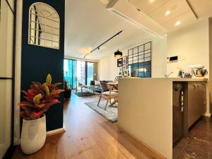 a kitchen and living room with a counter and a table at Luxury 2BR Apartment, Pool, Gym & Free Parking in Melbourne