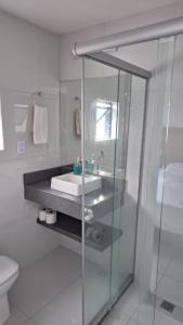 um banheiro com pia e box de vidro em Flat Vista Mar em Boa Viagem em Recife