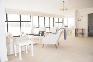 a living room with white chairs and a slide at Daisy Harbour View - Waterfront! in Raglan