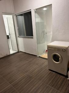 a bathroom with a washing machine and a shower at Temporada em Jauá in Camaçari