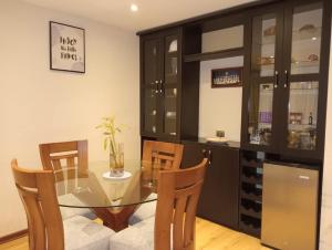 a dining room with a glass table and chairs at Spacious Apartment - Los Olivos in Lima