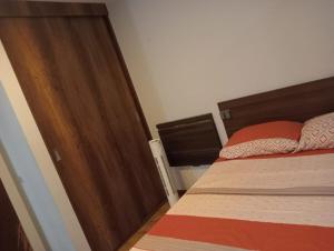 a bedroom with a bed and a wooden door at Spacious Apartment - Los Olivos in Lima
