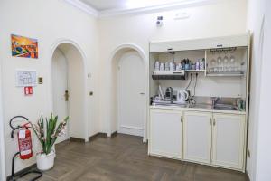 a kitchen with white walls and arches and a sink at Villa Matissa in Rome