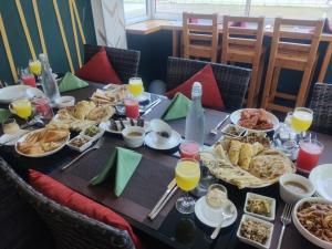 a table topped with plates of food and glasses of orange juice at Eydhafushi Home Stay Residence in Eydhafushi